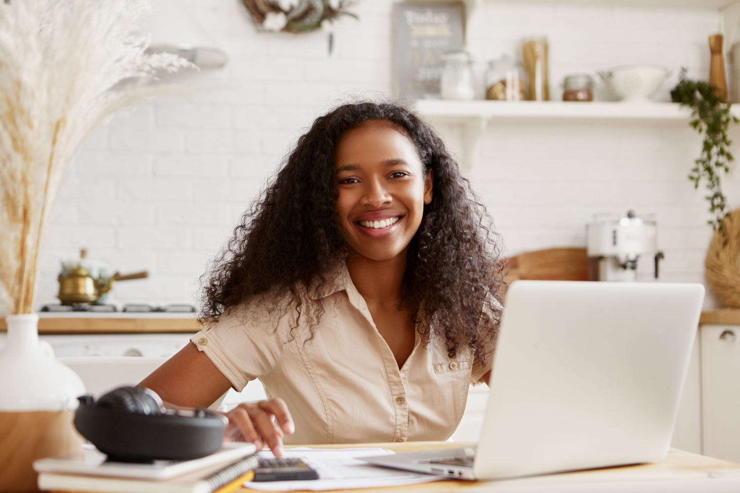 calculating-smiling-happily-self-employed-black-woman-working-from-home-1