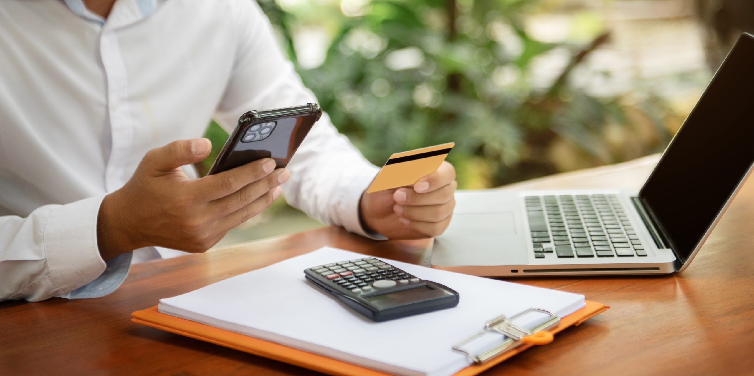os-investidores-usam-calculadora-estao-calculando-custos-de-investimento-e-segurando-smartphone-e-laptop-scaled